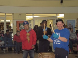 Man playing drum with band and crowd.